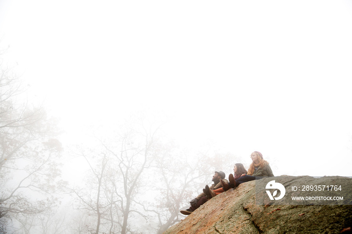 Friends sitting on rock