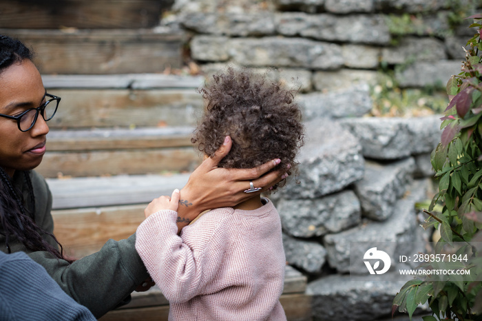 Close up of Biracial mothers hand holding sons head