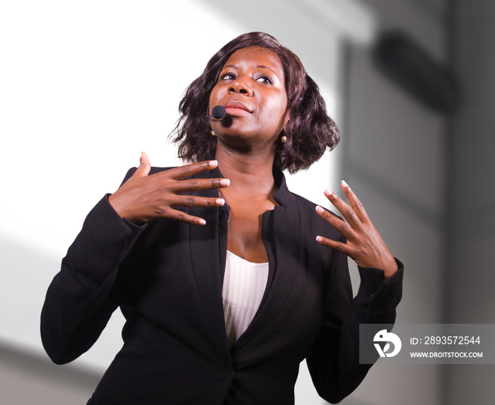 young attractive and confident black African American business woman with headset speaking in audito