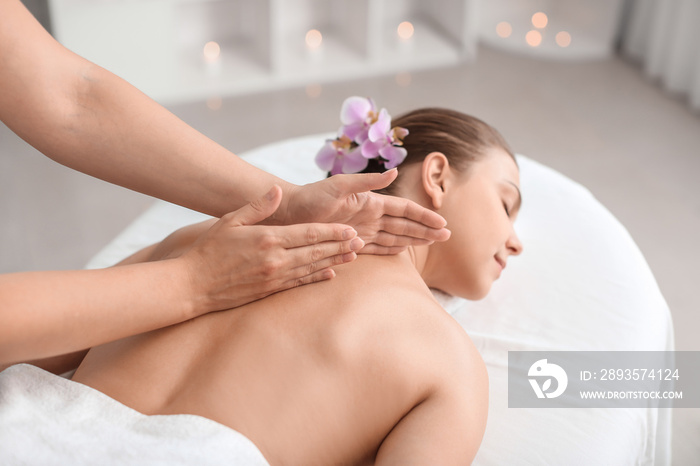 Beautiful young woman receiving massage in spa salon