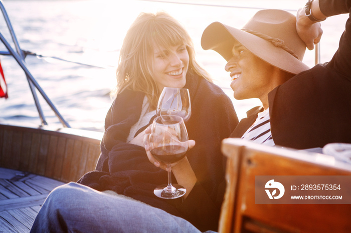 Young couple relaxing with wine on sailboat