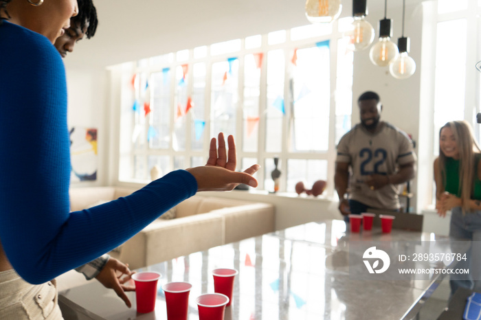 Friends�playing beer pong at home party