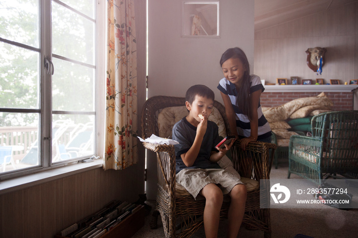 Friends (8-9) with smart phone in living room