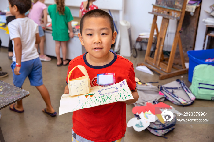 Young boy holding his completed arts and crafts