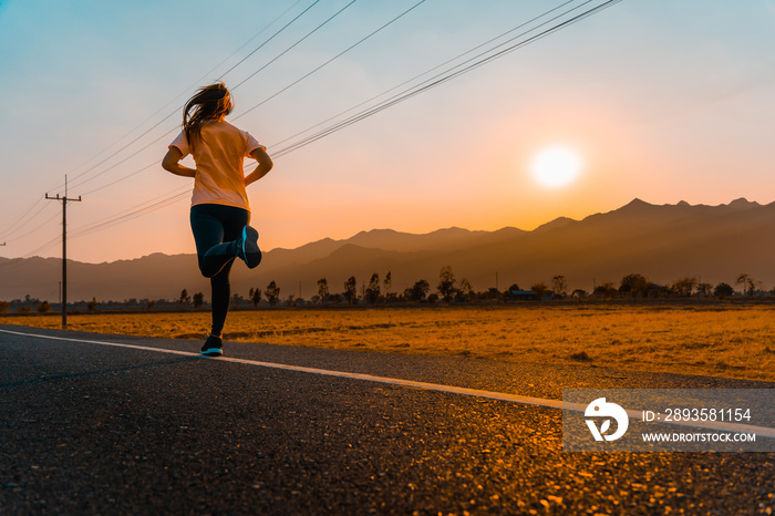 Asian woman enjoys running outside with beautiful summer evening in the countryside.