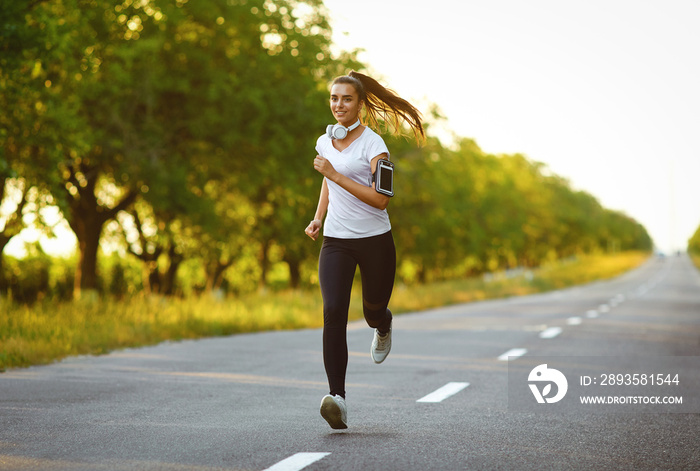 Girl runner runs along the road