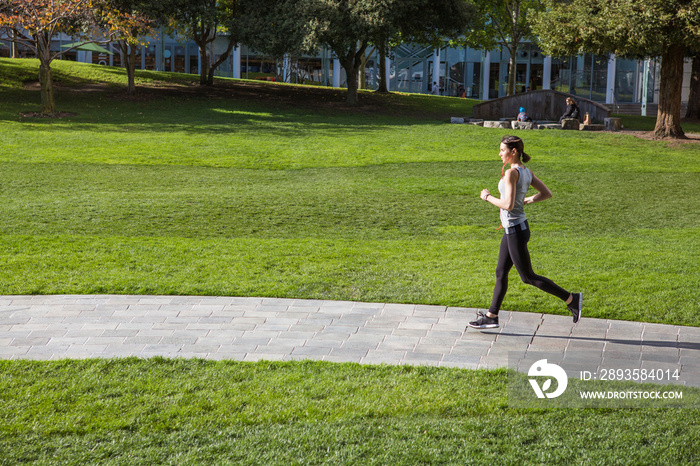 Woman running in park on sunny day