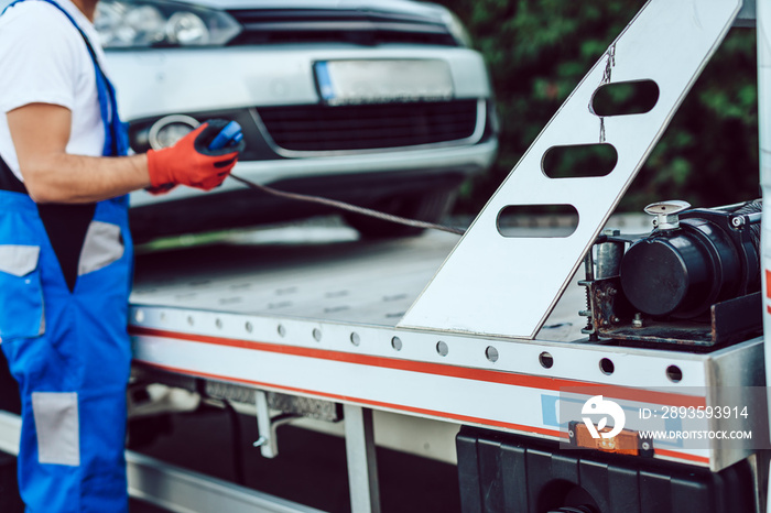 Handsome middle age man working in towing service on the road. Roadside assistance concept.