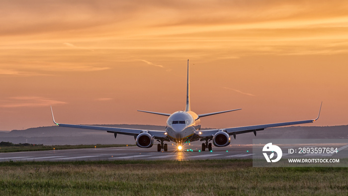 airplane landing at sunset