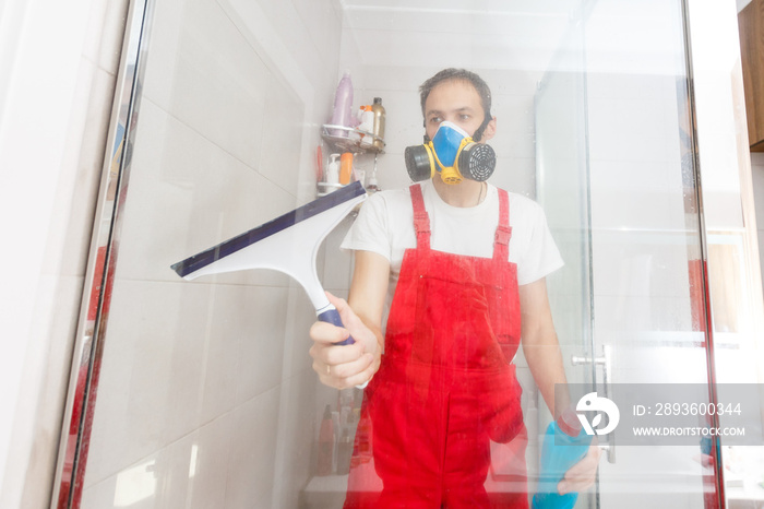 Man cleaning shower cabin.