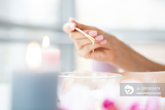 Close up women hold orange paraffin wax bowl