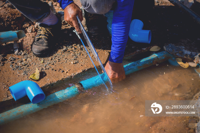 Construction worker,Repairing a broken water pipe on the concrete road.