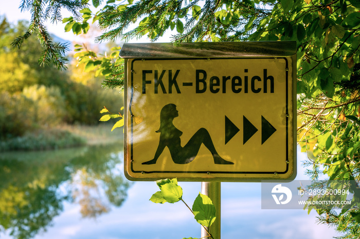 German sign board leading the way to the nude swimming area at the beach of lake Bibi in Bavaria