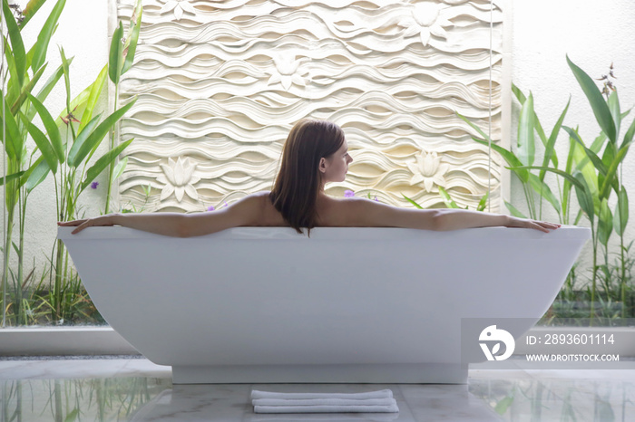 Portrait of a young woman relaxing in the bathtub, organic skin-care at the luxury hotel spa, wellbe