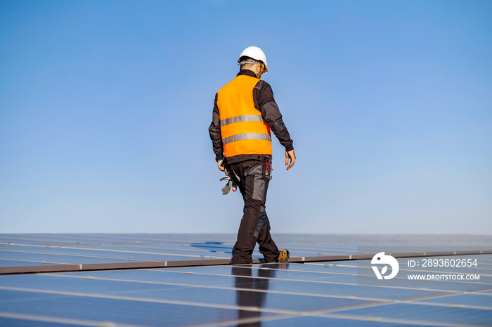 A worker on roof on his way to install solar panels.