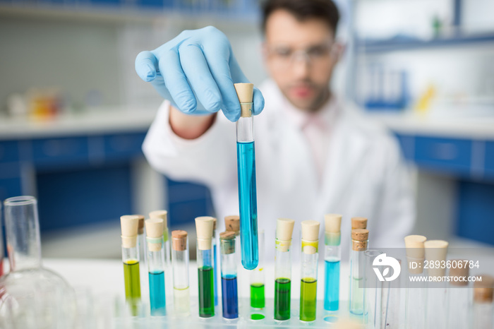 man scientist holding glass tube in hand in lab