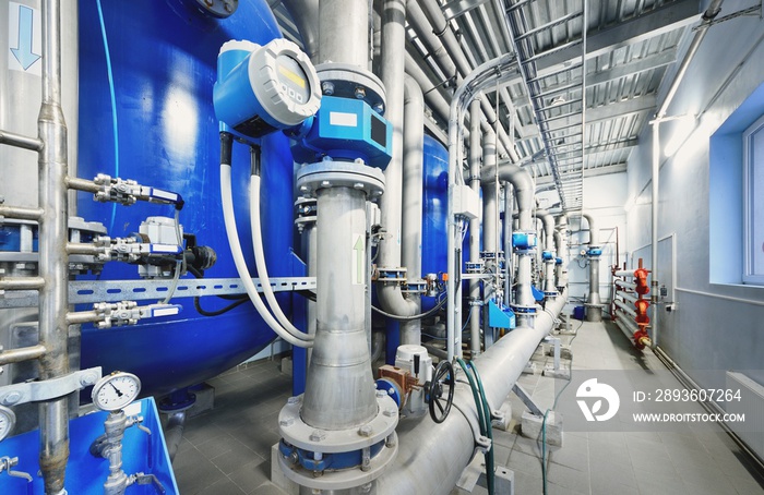 Large blue tanks in a industrial city water treatment boiler room. Wide angle perspective. Technolog