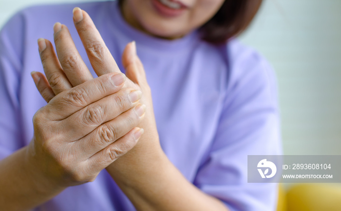 Woman using hand to hold other her palm with feeling pain, hurt and tingling. Concept of Guillain ba