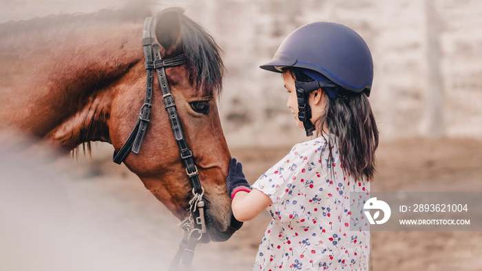 Asian school kid girl with horse ,riding or practicing horse ridding at horse ranch