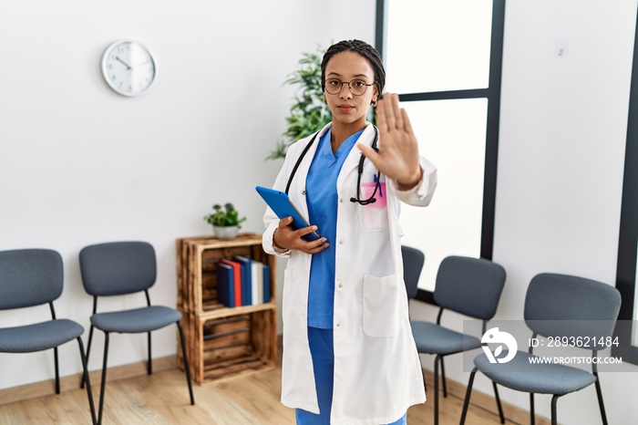 Young african american doctor woman at waiting room with open hand doing stop sign with serious and 