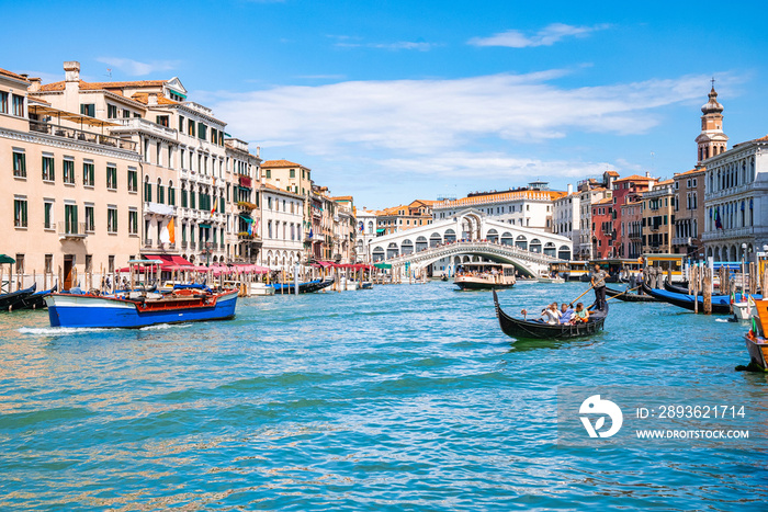 Magical view of traditional Gondola near world famous Canal Grande and Rialto Bridge at sunset in Ve