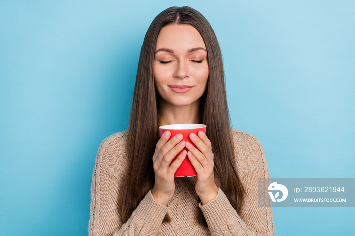 Portrait of attractive dreamy cheery girl drinking enjoying herbal tea isolated over bright blue col