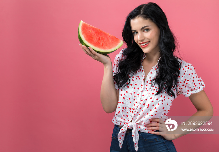 Young woman holding watermelon on a solid background