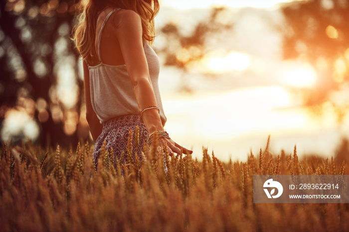 Young woman enjoying in a wheat field.