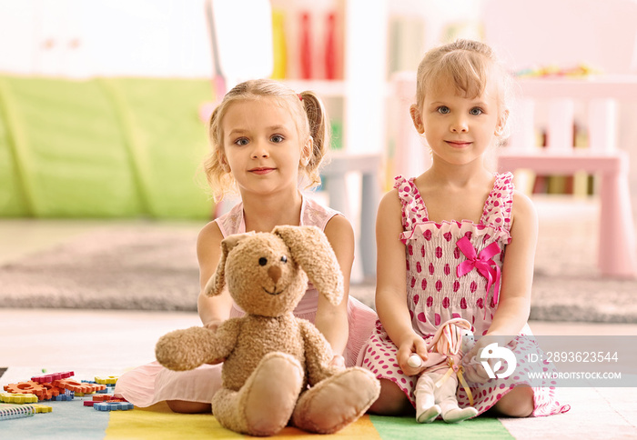 Cheerful little girls playing on floor