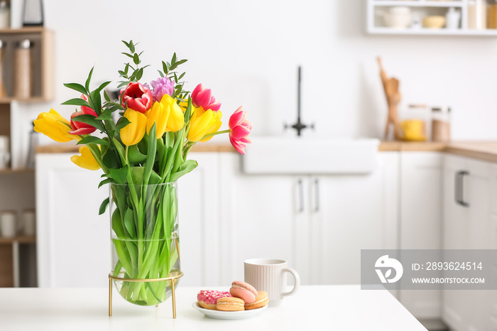 厨房桌子上摆着漂亮的鲜花和早餐的花瓶