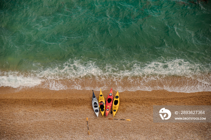 Colorful kayaks on sandy beach. Aquasport.