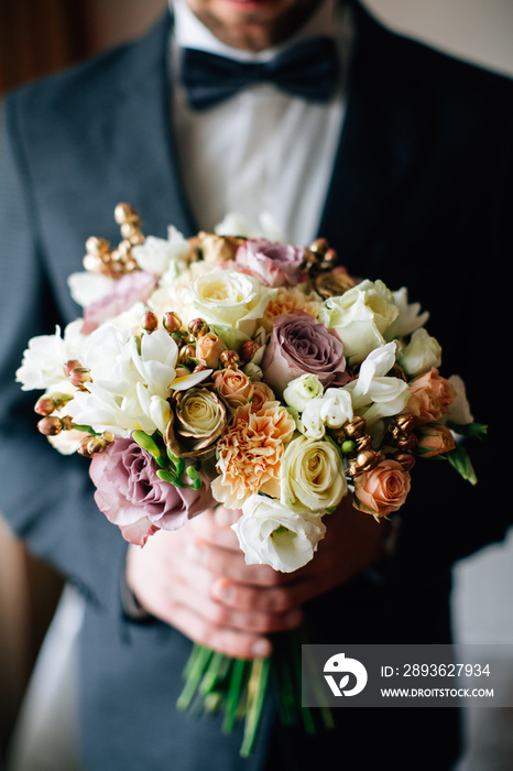 Groom holding beautiful wedding bouquet