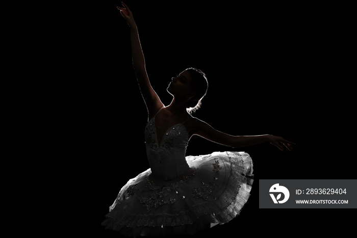 Silhouette of beautiful young ballerina on dark background