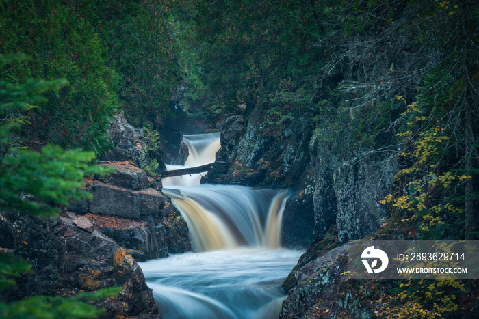 Waterfall flowing through rocky forest landscape