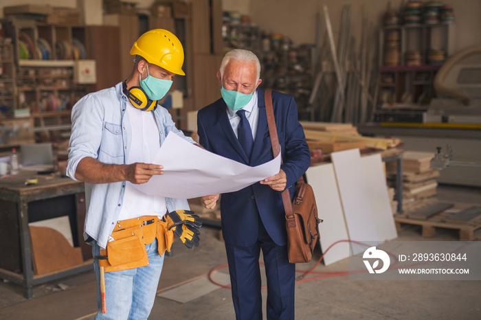 Carpenter showing blueprints to his manager