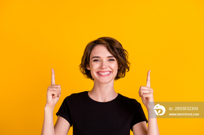 Close-up portrait of lovely glad cheerful girl pointing two forefingers up copy space isolated over 