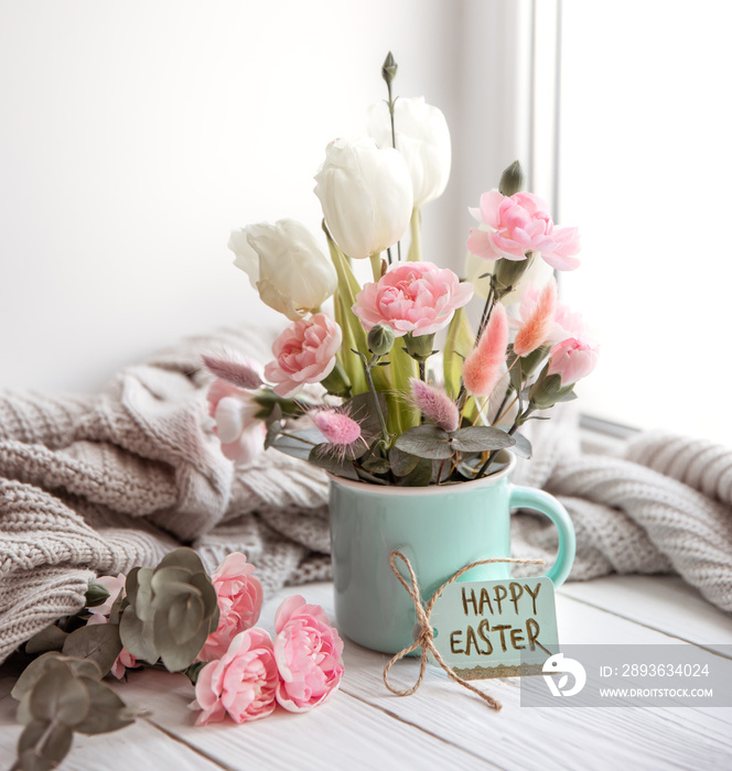 Easter floral arrangement with natural flowers and the inscription Happy Easter on the card.