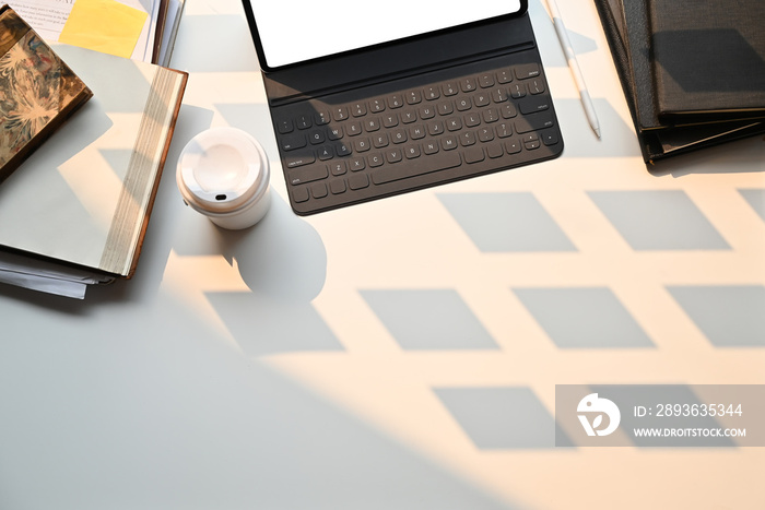 Creative desk workspace with mockup tablet computer and office equipment on black table, top view.