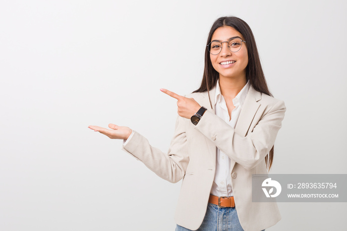 Young business arab woman isolated against a white background excited holding a copy space on palm.