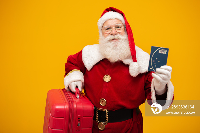 Santa Claus with his suitcase. Holding a brazilian passport. New Years travel concept. Santa Claus 