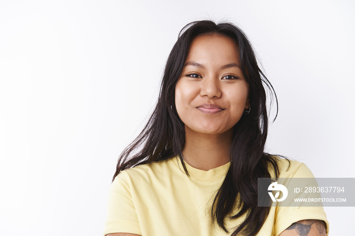 Close-up shot of amused enthusiastic good-looking malaysian woman with facial scars smiling feeling 