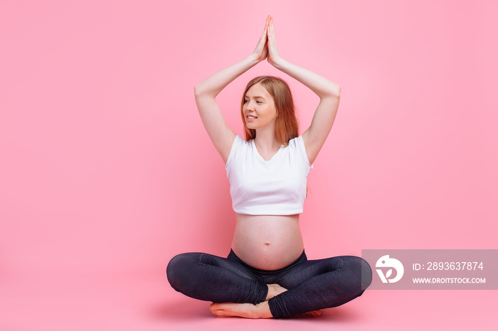 Young beautiful pregnant woman does yoga exercise