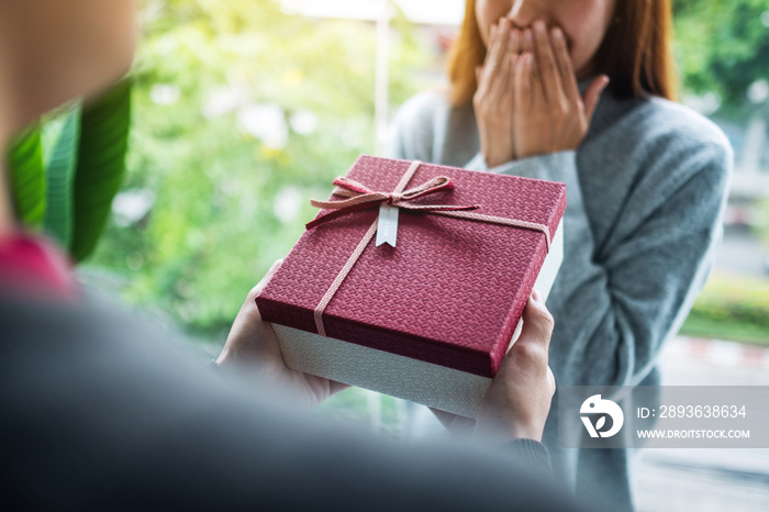 A boyfriend surprising and giving his girlfriend a gift box