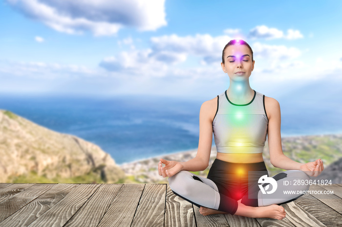 Beautiful young woman practicing yoga at resort