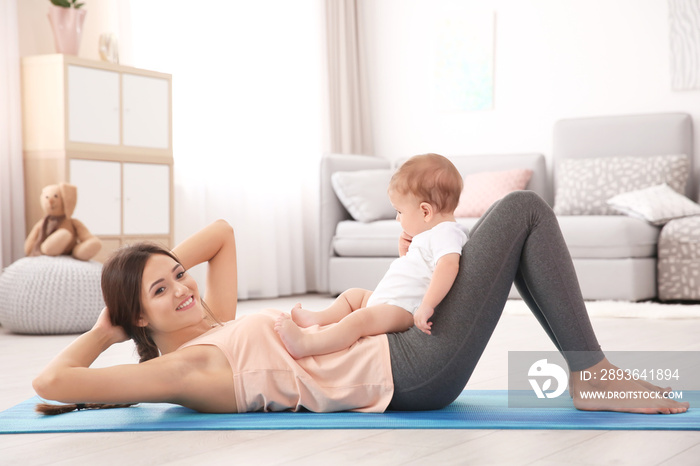 Young mother doing yoga with baby at home