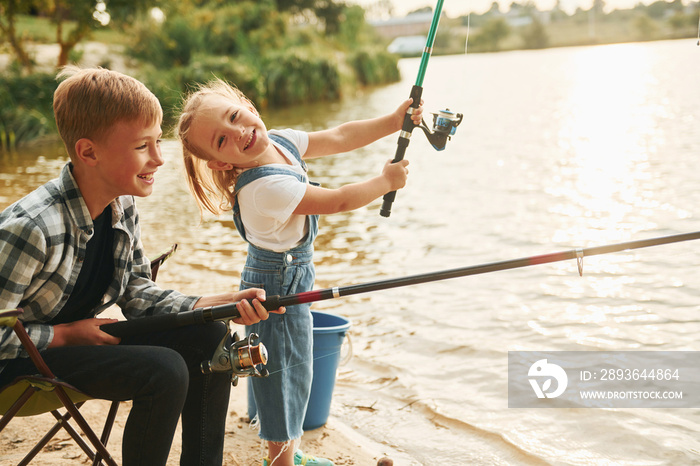 Having fun. Boy with his sister in on fishion outdoors at summertime together