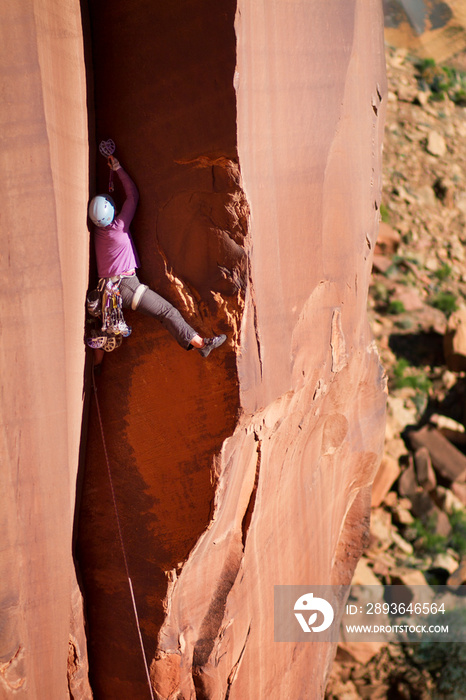 Rock climber on narrow rock wall