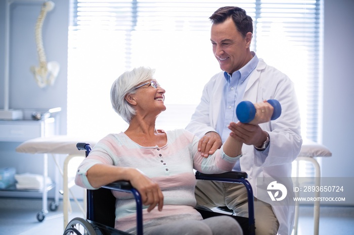 Physiotherapist assisting senior patient with hand exercise