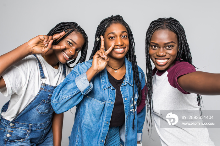 Young pretty african women friends take selfie on the phone isolated on white background