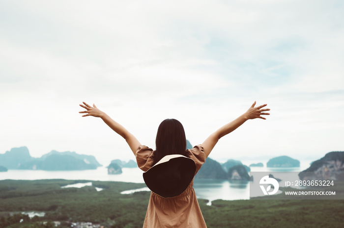 Freedom concept. Happy young woman enjoying freedom time and open hands on nature river and mountain